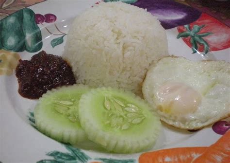  Nasi Lemak:  สัมผัสรสชาติเข้มข้นของスパイスและความหอมมันเย้ายวนจากน้ำกะทิที่ถูกเคี่ยวอย่างช้าๆ